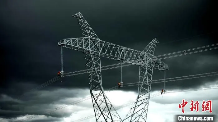 电力建设人员正在高空进行附件安装施工。　侯雅馨 摄