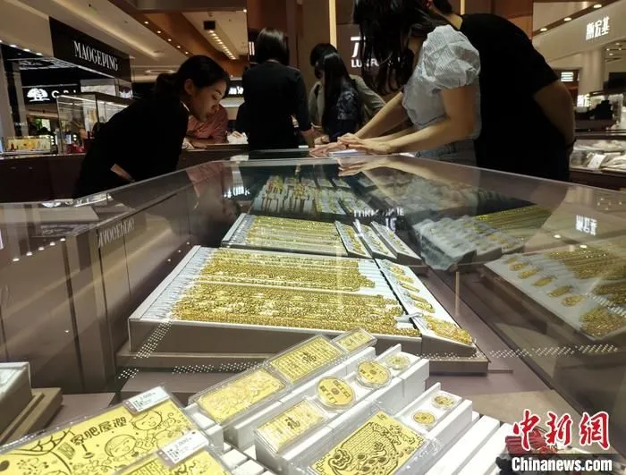 图为民众当日在福州一黄金饰品店挑选黄金饰品。中新社记者 吕明 摄