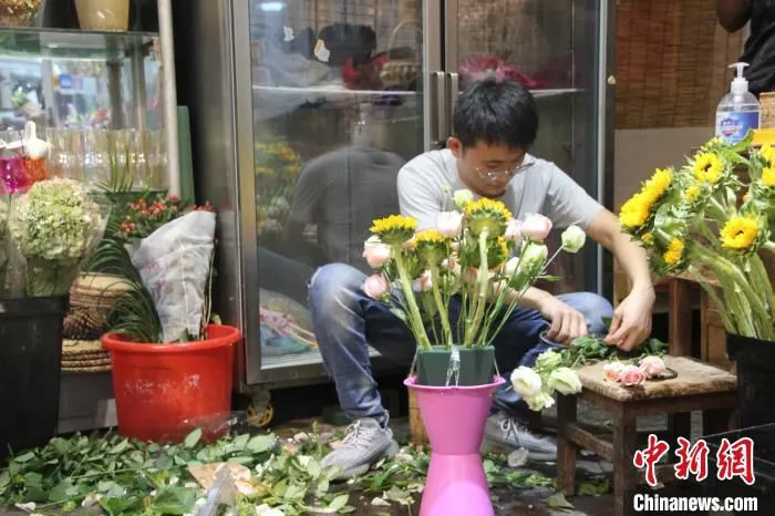 图为一名男子正在插花做花束。　李明明 摄
