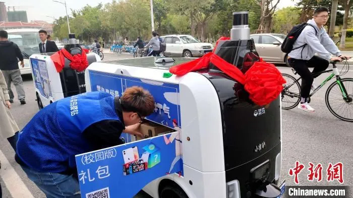 菜鸟驿站物流人员将快递放入菜鸟无人车小蛮驴。　杨伏山 摄