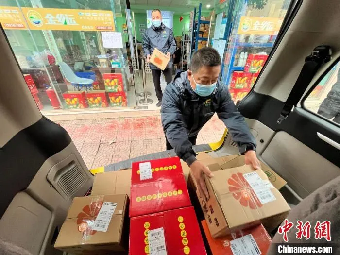 在金堂县三溪镇“金乡运”服务点，司机装载包装好的脐橙。　张浪 摄