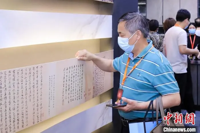 采购商在第四届中国(晋江)国际家装建材博览会上感受薄如纸片的瓷砖产品。　孙虹 摄