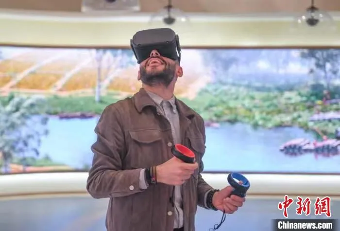 福迪尔戴上VR眼镜，体验古时的猎鹿和捕鱼。　王刚 摄