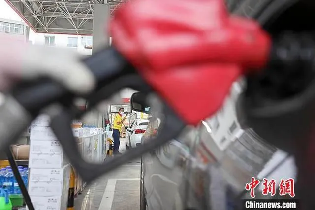 资料图：工作人员给车辆加油。 中新社记者 张云 摄