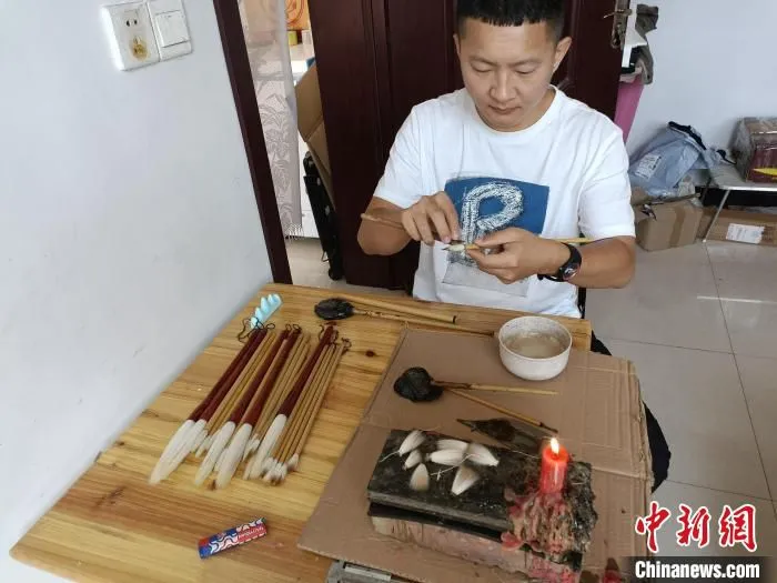 “崔氏毛笔”第四代传人崔大帅在完成制作毛笔的最后一道工序。 王天译 摄 “崔氏毛笔”第四代传人崔大帅在完成制作毛笔的最后一道工序。 王天译 摄