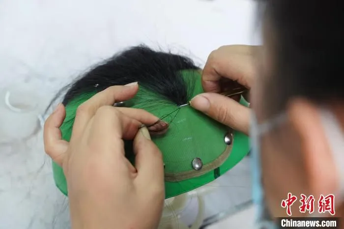 图为工人正在制作假发制品。　闫志国 摄