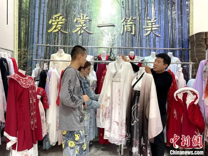王逢青在汉服展销馆为顾客介绍汉服。　孙宏瑗 摄