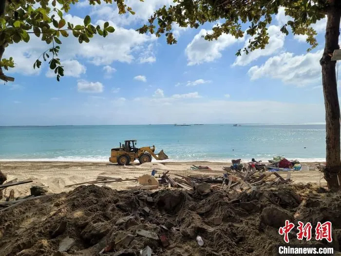一辆施工铲车行驶在大东海沙滩上。　王晓斌 摄
