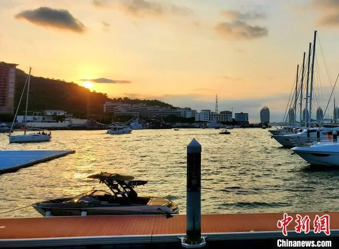 夕阳下，一艘造浪艇靠泊在码头边。　王晓斌 摄