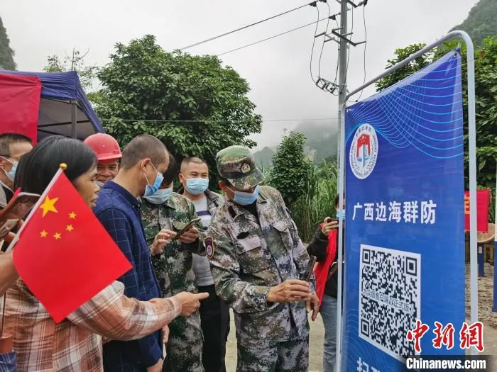 图为边境地区民兵为群众讲解“广西边海群防”APP。　黄秋艳 摄