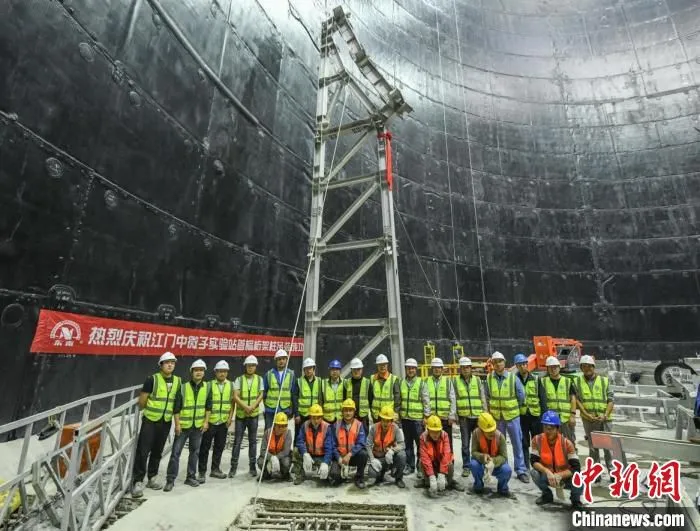 江门中微子实验中心探测器的不锈钢网壳主结构第一榀支撑柱吊装落位，工程技术人员合影留念。　中科院高能所 供图