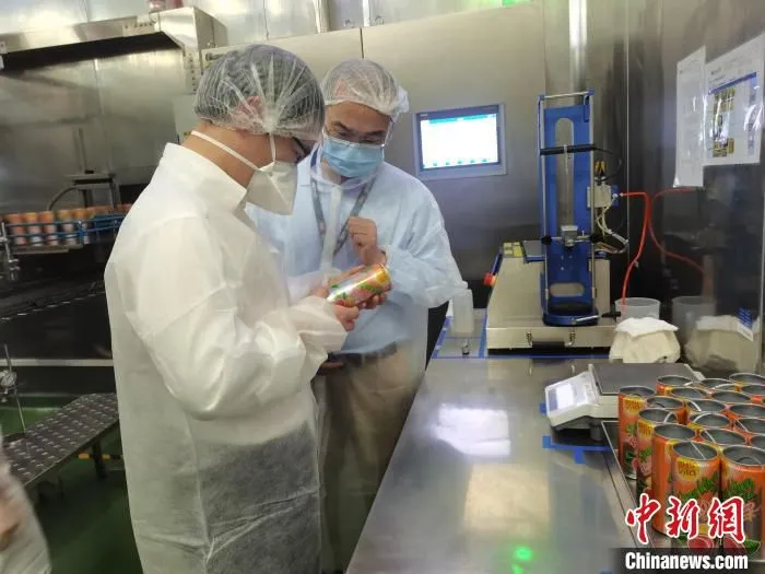监管人员在企业罐装车间，检查企业产品标注情况。　上海市场监管局供图