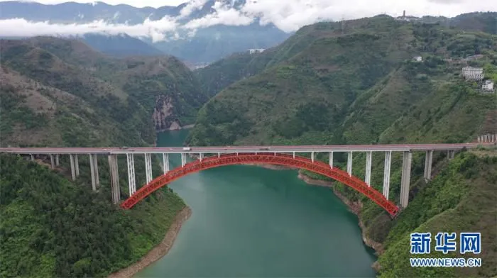 4月8日，G42沪蓉高速大宁河大桥与青山绿水白云相映成画。新华网 向进 摄