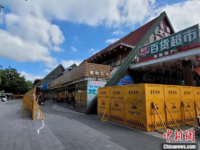 施工围挡留出口子，供商家搬离物品。　王晓斌 摄