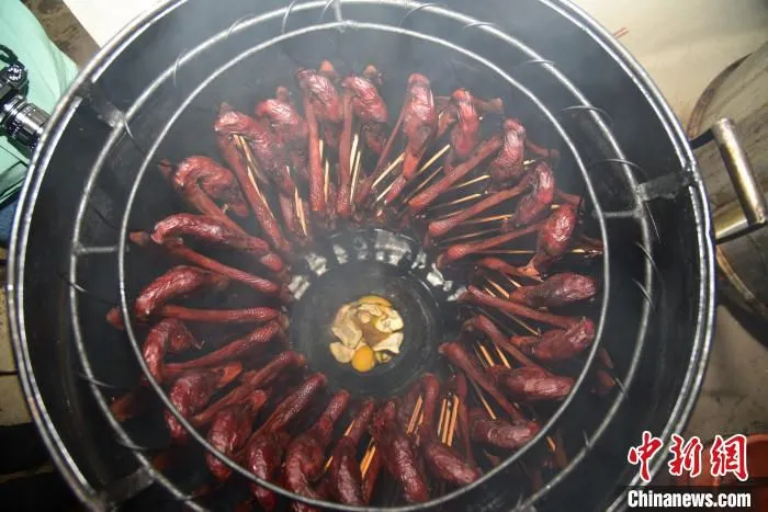 正在炭烤的腊鸭。　王以照 摄