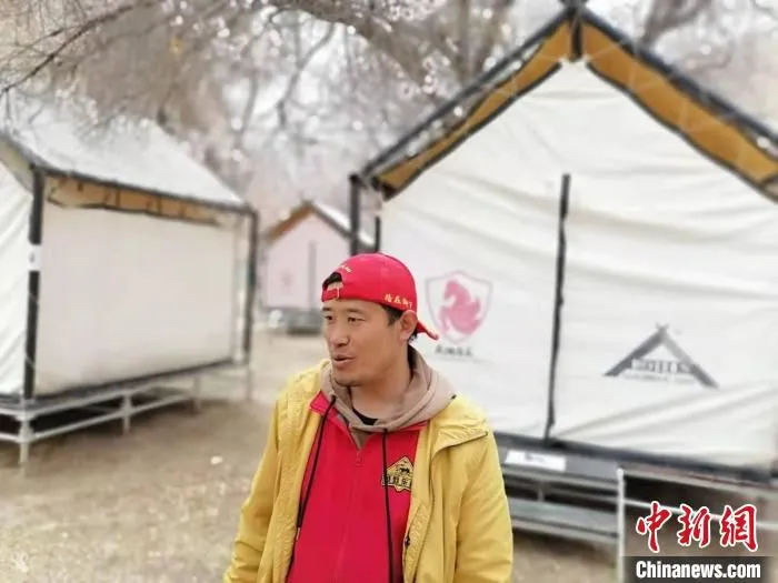 河边的一块空地上，15个帐篷错落分布，接待观赏杏花的游客。　朱景朝 摄
