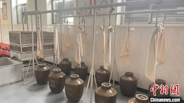 山西省非遗“代县黄酒酿造技艺”保护单位代县四达酒类饮料有限公司黄酒酿造工厂展示的古法酿黄酒吊包工序。　王斌田 摄