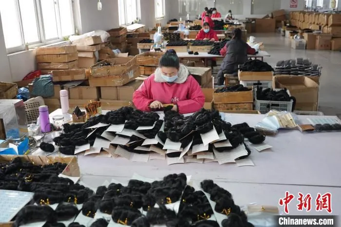 图为工人们正在制作假发制品。　闫志国 摄