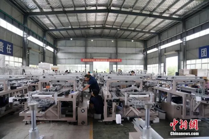 资料图：工人在车间忙碌。
中新社记者 苏丹 摄