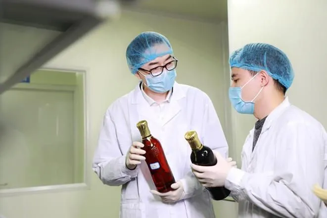 听花酒总设计师张雪峰在听花实验室与科研人员研究酒体