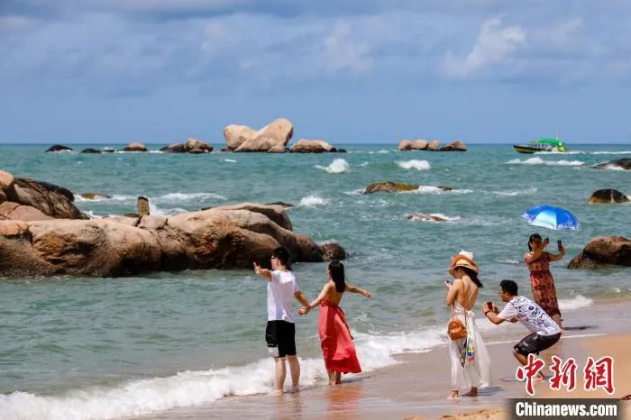  游客在天涯海角的海边沙滩“拥抱大海”。　范勇　摄
