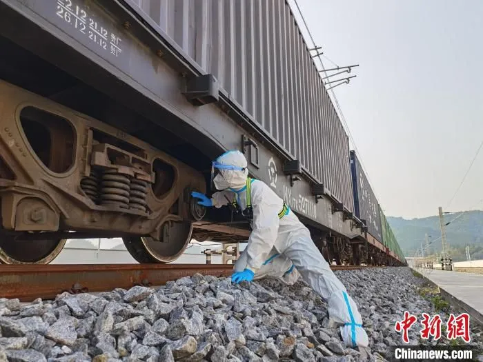图为民警正在对班列进行查验。　磨憨出入境边防检查站供图