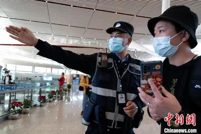 图为机场安保人员为旅客提供服务。 程征宇 摄 图为机场安保人员为旅客提供服务。 程征宇 摄