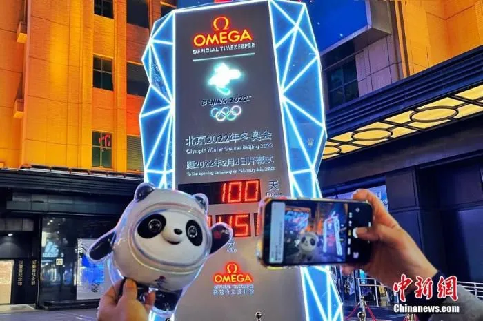 北京2022冬奥会倒计时牌前，市民和游客在倒计时100天时记录留念。图片来源：视觉中国
