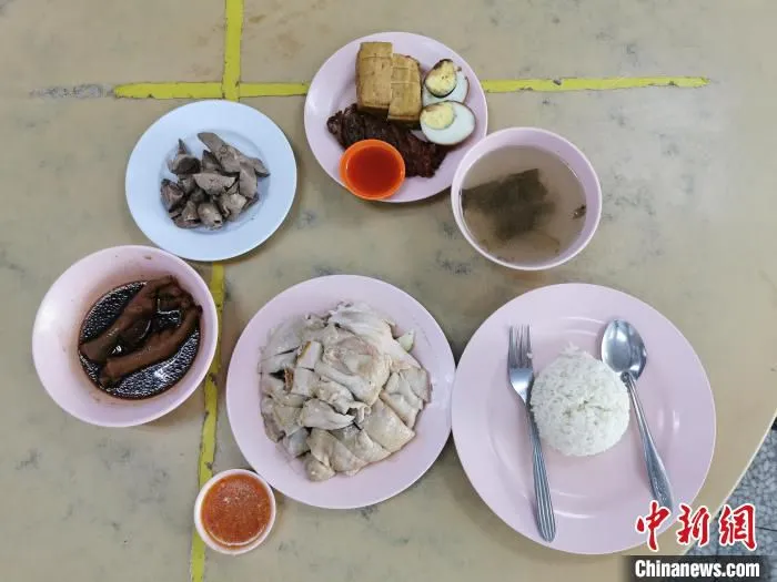 马来西亚槟城老字号“文昌海南鸡饭店”制作的搭配卤蛋、五香肉、鸡爪等的海南鸡饭。　郑翔鹏 摄