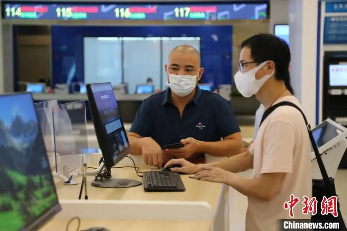 税务人员正在辅导纳税人操作网上税务系统。　广东省税务局供图