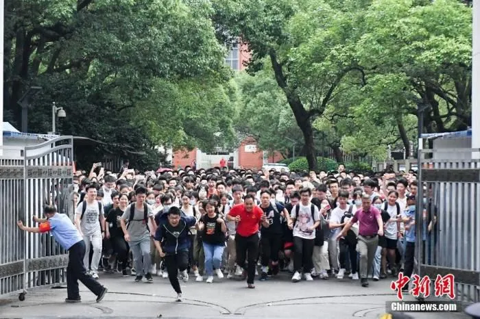 6月9日，考生与老师一同冲出长沙市一中考点。当日，湖南省考生结束2021年全国高考。 中新社记者 杨华峰 摄