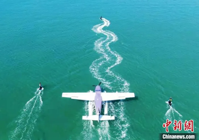 电动冲浪板和水上飞机一同在海面上滑行。　三亚海空驿站供图