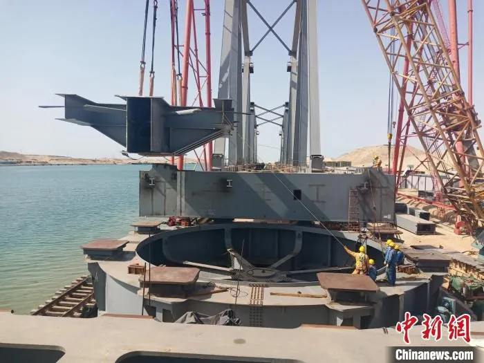 埃及苏伊士运河铁路桥新桥西岸主塔履带吊安装塔柱斜腹杆现场。　四川路桥供图
