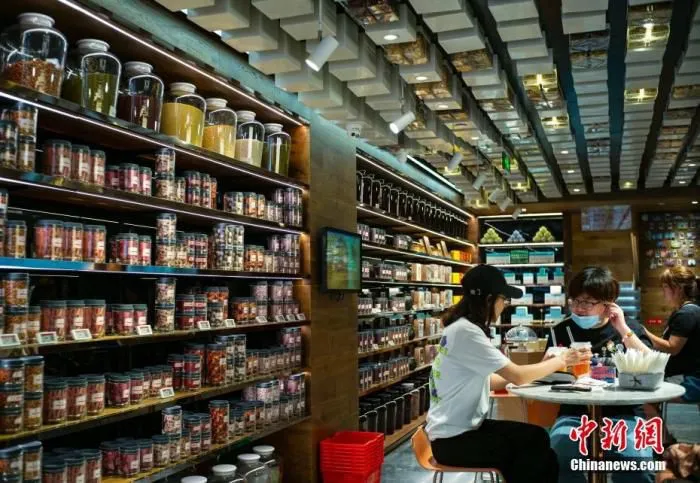 资料图：北京市一家“同仁堂知嘛健康”店内，顾客或坐饮咖啡饮料，或选购健康食材。 中新社记者 侯宇 摄