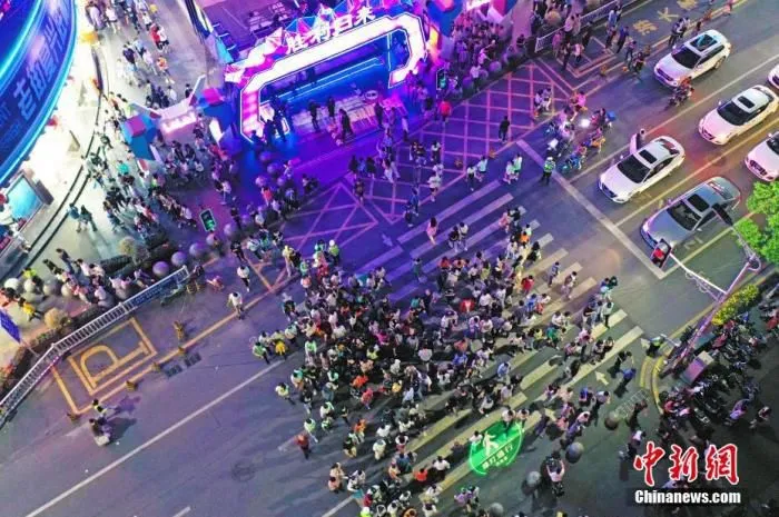 5月2日晚，江西南昌，民众在胜利路步行街休闲购物。为恢复百年老街的往日繁华，当地开展胜利路步行街“胜利归来” 主题活动，打造潮玩、消费于一体的活动街区，“五一”假期吸引民众，形成新的节日经济、夜间经济和文化经济。(无人机照片) 中新社记者 刘占昆 摄