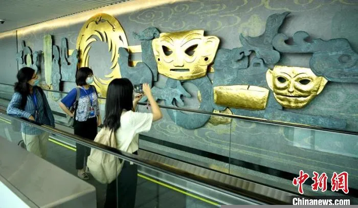T2国际到达旅客通道墙上的“三星堆”元素吸引过往者拍照。　刘忠俊 摄