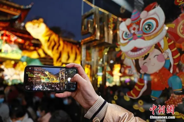 图为游客用手机拍摄生肖虎灯。 殷立勤 摄