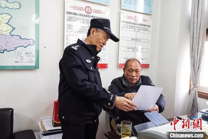 图为张仲云正在与同事讨论工作。　开远铁路公安处供图