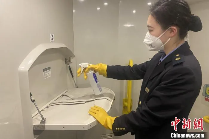 1月18日，在由南昌客运段值乘的G2777次列车上，疫情防控期间乘务员对车厢重点部位进行消毒。　 郑璐瑶 摄