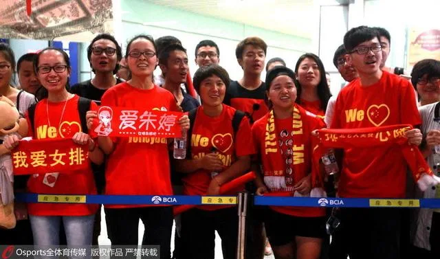 女排载誉回国球迷拉横幅迎接 粉丝现场唱国歌
