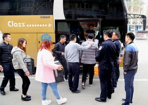 警方调来大巴车将几十名涉嫌诈骗嫌疑人带走
